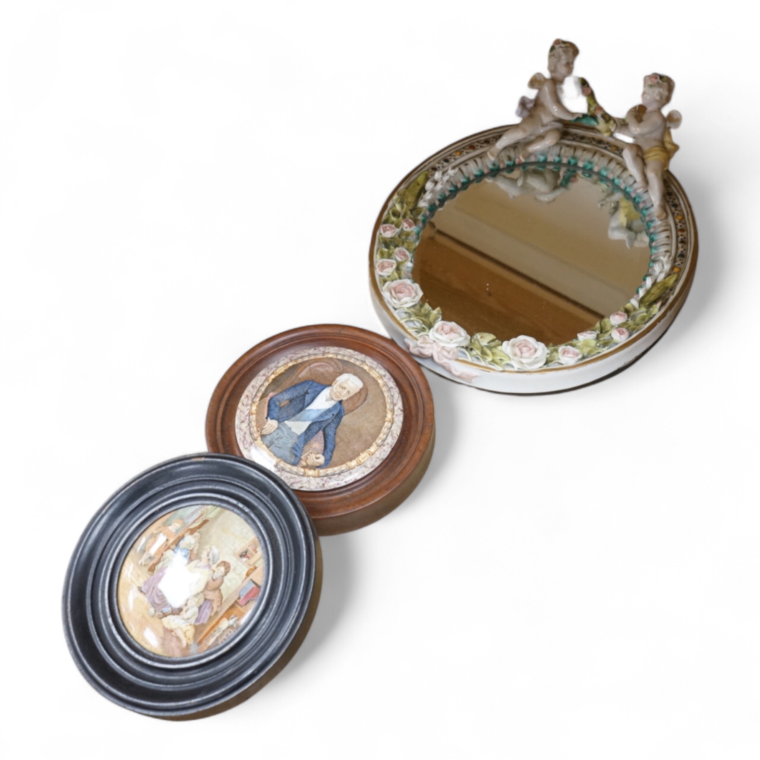 A Duke of Wellington pot lid, another Prattware pot lid and a German floral encrusted porcelain mirror, largest 33cm high